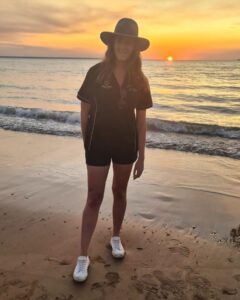 Kellie standind on Darwin's Mindil Beach at sunset wearing an Akubra hat